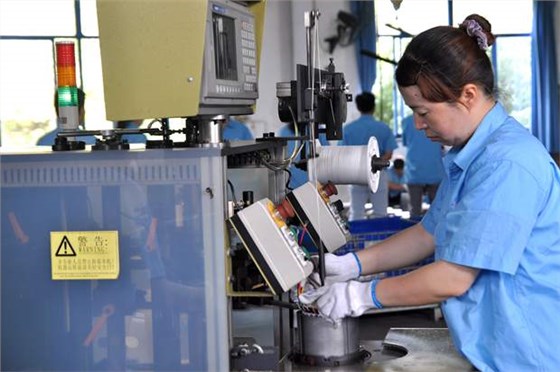 皖南電機(jī)員工在操作自動嵌線設(shè)備 皖南電機(jī)員工在操作自動嵌線設(shè)備
